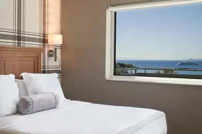 a bedroom with a white bed and a window at Sea View Cityscape Hotel in Athens