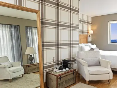 a bedroom with a bed and a mirror and a chair at Sea View Cityscape Hotel in Athens