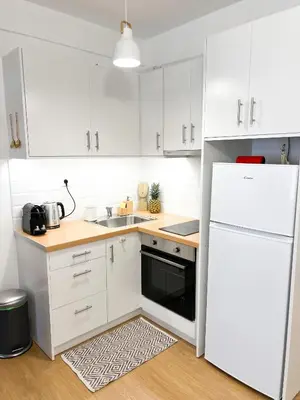 a kitchen with white cabinets and a white refrigerator at Comfy 2 BDR Apt in Petralona - Next to metro in Athens