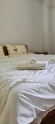 a white bed with a towel on top of it at A peaceful apartment in Athens in Athens