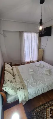a large bed in a room with a window at A peaceful apartment in Athens in Athens