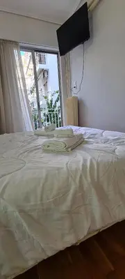 a bedroom with a large white bed with a window at A peaceful apartment in Athens in Athens