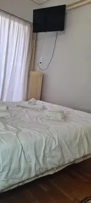 a bedroom with a bed with a television on the wall at A peaceful apartment in Athens in Athens