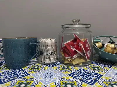 a table with a jar of sugar and a cup at Cozy apartment near the city center and beaches in Athens