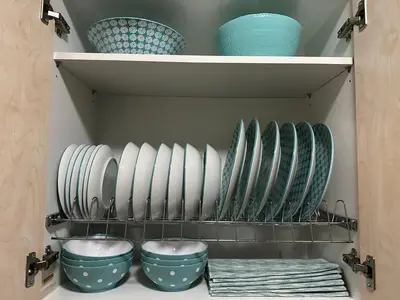 a shelf with plates and bowls in a kitchen at Cozy apartment near the city center and beaches in Athens