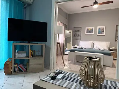 a living room with a bed and a flat screen tv at Cozy apartment near the city center and beaches in Athens
