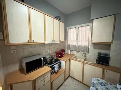 a small kitchen with a microwave and a sink at Cozy apartment near the city center and beaches in Athens