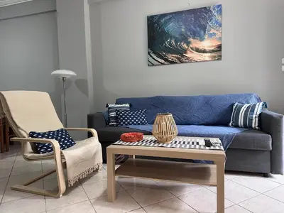 a living room with a blue couch and a table at Cozy apartment near the city center and beaches in Athens