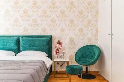 a bedroom with a bed and a green chair at New Huge 5BDR/2bath Apt(+netflix)/1min toAcropolis in Athens