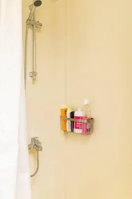 a bathroom with a shelf on the wall with toiletries at New Huge 5BDR/2bath Apt(+netflix)/1min toAcropolis in Athens