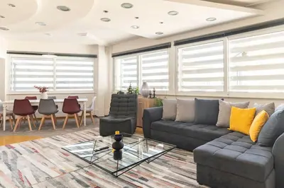 a living room with a couch and a table at HighEnd 5BDR NewApt w/Breathtaking Acropolis View in Athens