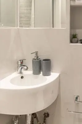 a white bathroom sink with two cups on it at HighEnd 5BDR NewApt w/Breathtaking Acropolis View in Athens
