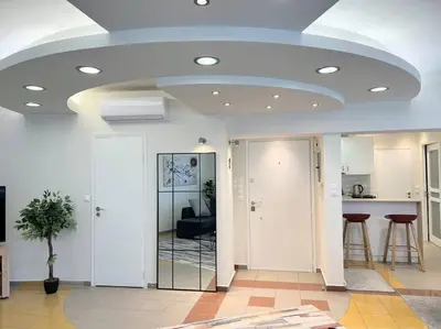 a living room with a vaulted ceiling and a kitchen at HighEnd 5BDR NewApt w/Breathtaking Acropolis View in Athens