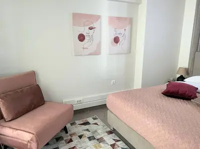 a bedroom with a bed and a couch and pictures on the wall at HighEnd 5BDR NewApt w/Breathtaking Acropolis View in Athens