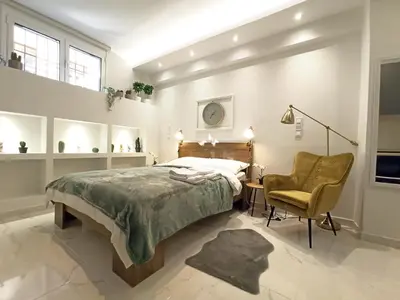 a bedroom with a bed and a chair and a desk at Mikalis Studio in Athens