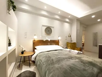 a bedroom with a large bed with a clock on the wall at Mikalis Studio in Athens