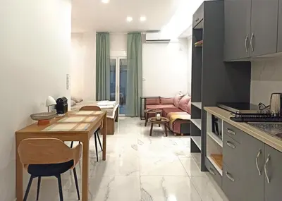 a kitchen and living room with a table and chairs at Mikalis Studio in Athens