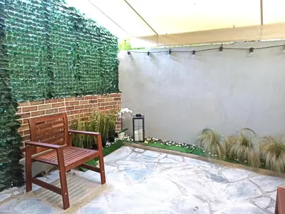a wooden bench sitting on a patio next to a brick wall at Mikalis Studio in Athens