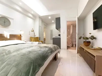 a bedroom with a large bed and a clock on the wall at Mikalis Studio in Athens
