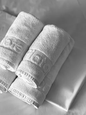 two rolled up towels sitting on top of a bed at Platon Hotel in Piraeus