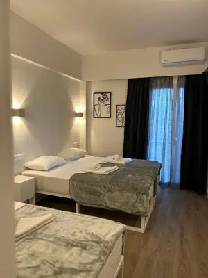 a hotel room with two beds and a window at Platon Hotel in Piraeus