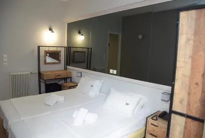a bedroom with a white bed with a large mirror at Platon Hotel in Piraeus