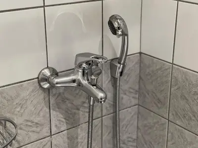 a shower with a shower head in a bathroom at Platon Hotel in Piraeus