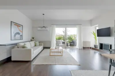 a white living room with a couch and a table at Panoramic 1BR Apartment near Kallimarmaro Stadium by UPSTREET in Athens