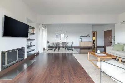 a living room with a fireplace and a table at Panoramic 1BR Apartment near Kallimarmaro Stadium by UPSTREET in Athens