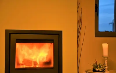a fireplace with a candle in a room at Spacious & Minimal Apartment Near Airport Peania Coniann Filoxenia in Paianía