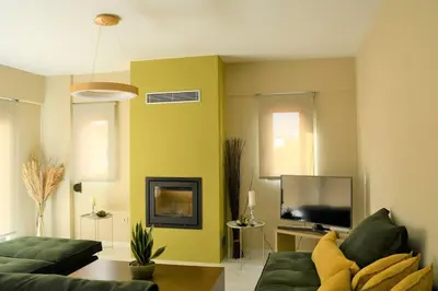 a living room with a green couch and a tv at Spacious & Minimal Apartment Near Airport Peania Coniann Filoxenia in Paianía