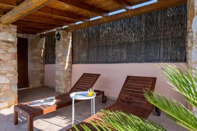 two chairs and a table on a patio at Phoceus Poolfront Grande Villa in Palaiá Fókaia