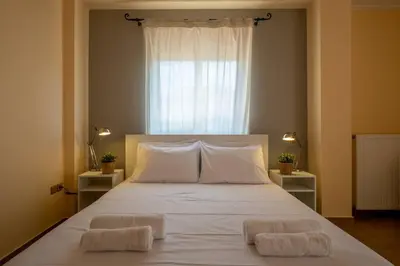 a bedroom with a large white bed with two pillows at Phoceus Poolfront Grande Villa in Palaiá Fókaia