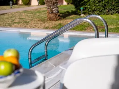 a swimming pool with a metal handrail next to a swimming pool at Phoceus Poolfront Grande Villa in Palaiá Fókaia