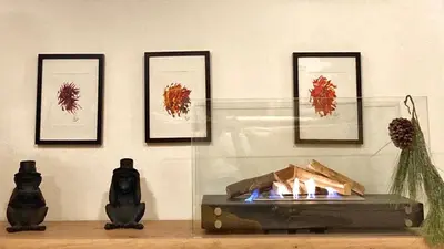 a room with a fireplace and framed pictures on a wall at Avant-Garde Studio in Athens