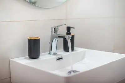a bathroom sink with a faucet and a mirror at Athens F&K Aphrodite Apartment in Athens