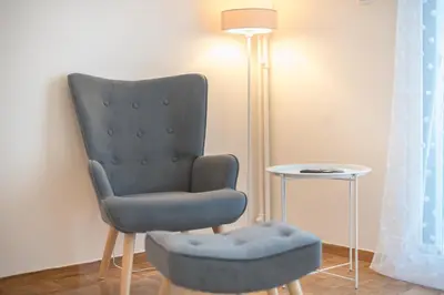 a blue chair and a stool next to a lamp at Athens F&K Aphrodite Apartment in Athens