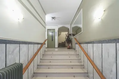 a staircase in a building with a green door at Athens F&K Aphrodite Apartment in Athens