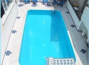 a large blue swimming pool on top of a building at Senia Studios in Agia Marina Aegina