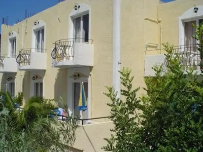 a building with a flag in front of it at Senia Studios in Agia Marina Aegina