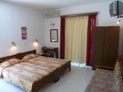 a bedroom with a bed and a television in it at Senia Studios in Agia Marina Aegina