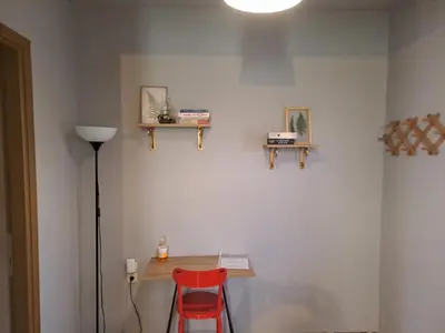 a room with a table and a red chair at Dimitris place near Athens airport in Koropíon