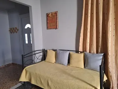 a bedroom with a bed with pillows on it at Dimitris place near Athens airport in Koropíon