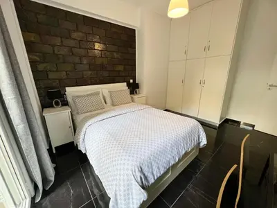 a bedroom with a bed and a brick wall at Beautiful Studio With Private Yard in Athens