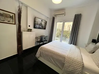 a bedroom with a white bed and a window at Beautiful Studio With Private Yard in Athens