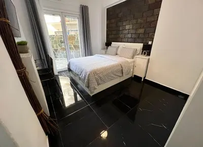 a bedroom with a bed and a brick wall at Beautiful Studio With Private Yard in Athens