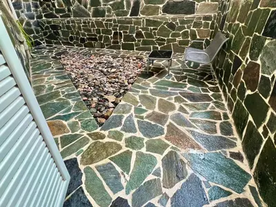 a stone walkway with a chair in a stone wall at Beautiful Studio With Private Yard in Athens
