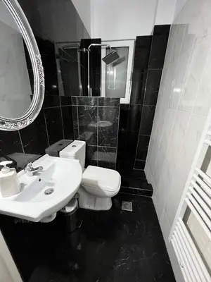 a black and white bathroom with a toilet and a sink at Beautiful Studio With Private Yard in Athens