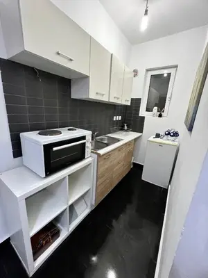 a white kitchen with a stove and a sink at Beautiful Studio With Private Yard in Athens