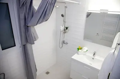 a white bathroom with a sink and a mirror at Aroura Neoclassical Home 3BR 2BA in Athens
